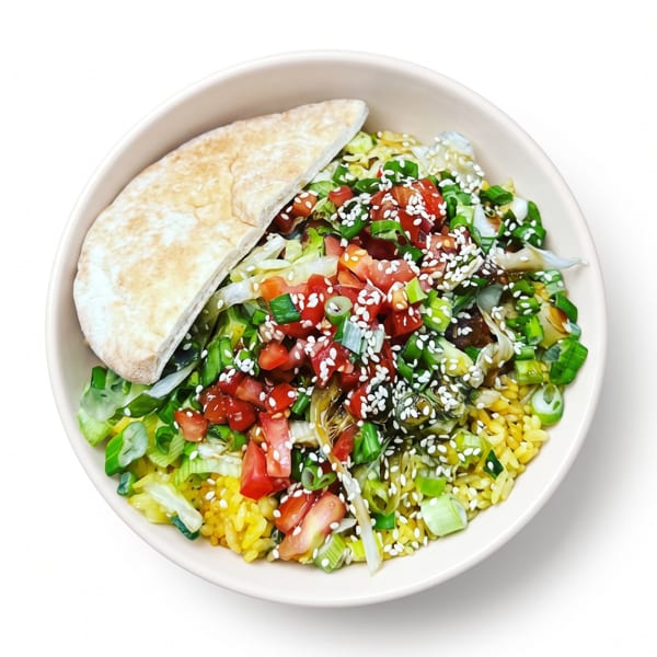 Bowl of yellow rice topped with tomatoes, green onions, sesame seeds, and pita bread.